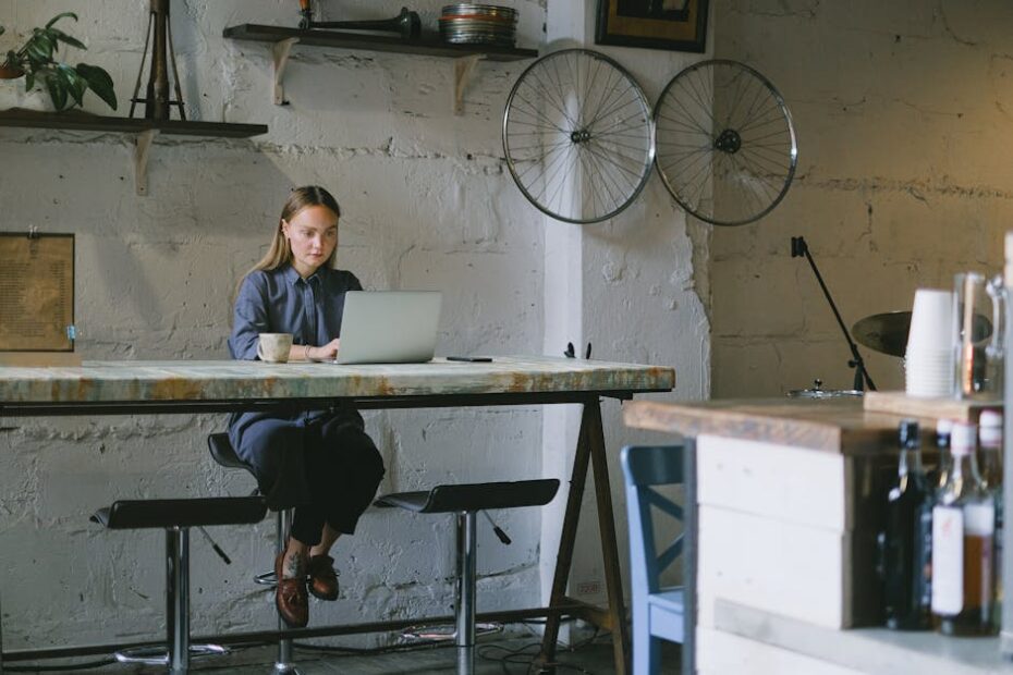 Young woman working on a laptop in a modern cafe with a rustic ambiance.