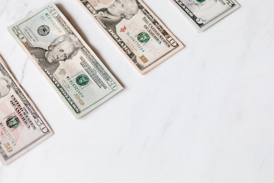 US dollar banknotes arranged on a clean white surface, showcasing different denominations.