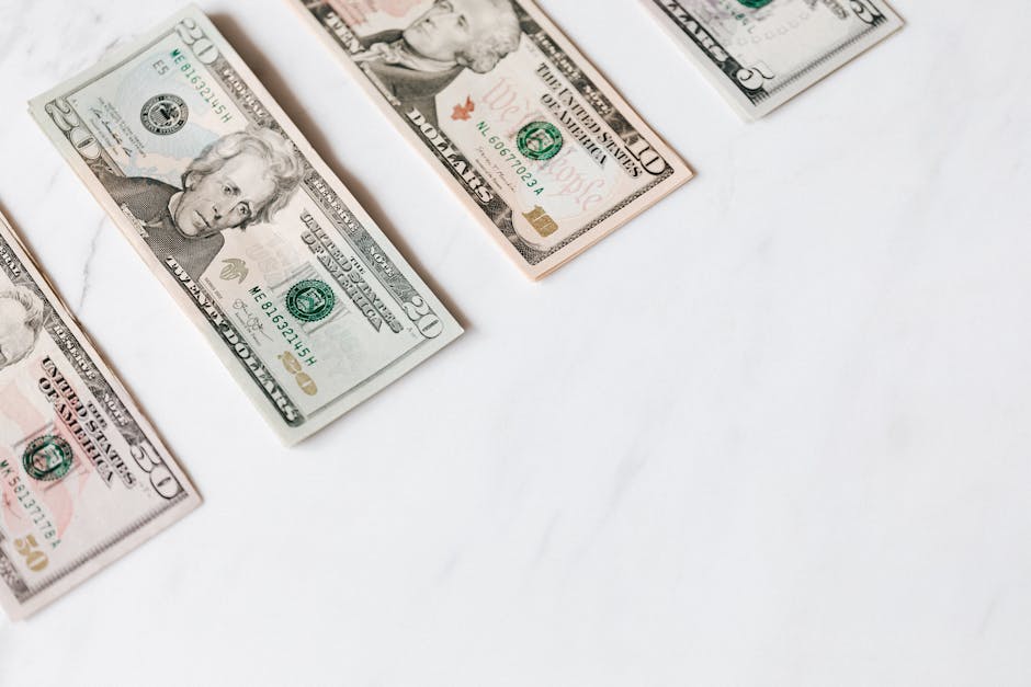 US dollar banknotes arranged on a clean white surface, showcasing different denominations.